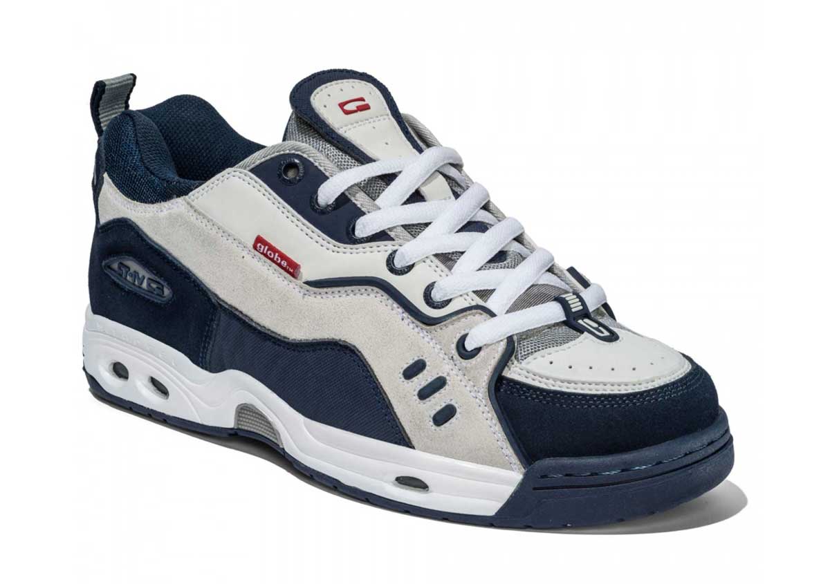 A navy blue, white, and gray skate shoe with a thick rubber sole, white laces, and mixed suede and fabric panels, viewed from an angle showing the side and front.