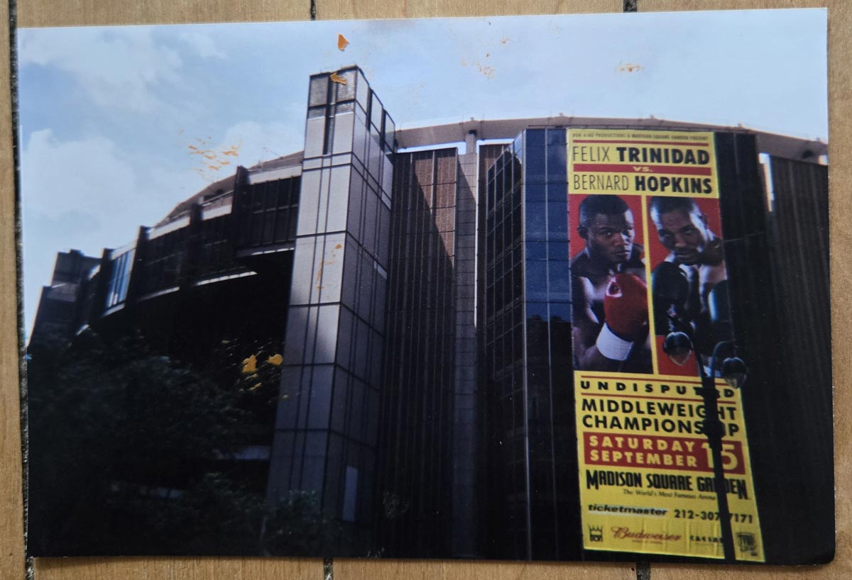 A large building with a tall poster advertising a boxing match between Felix Trinidad and Bernard Hopkins is shown; the event is scheduled for September 15 at Madison Square Garden.