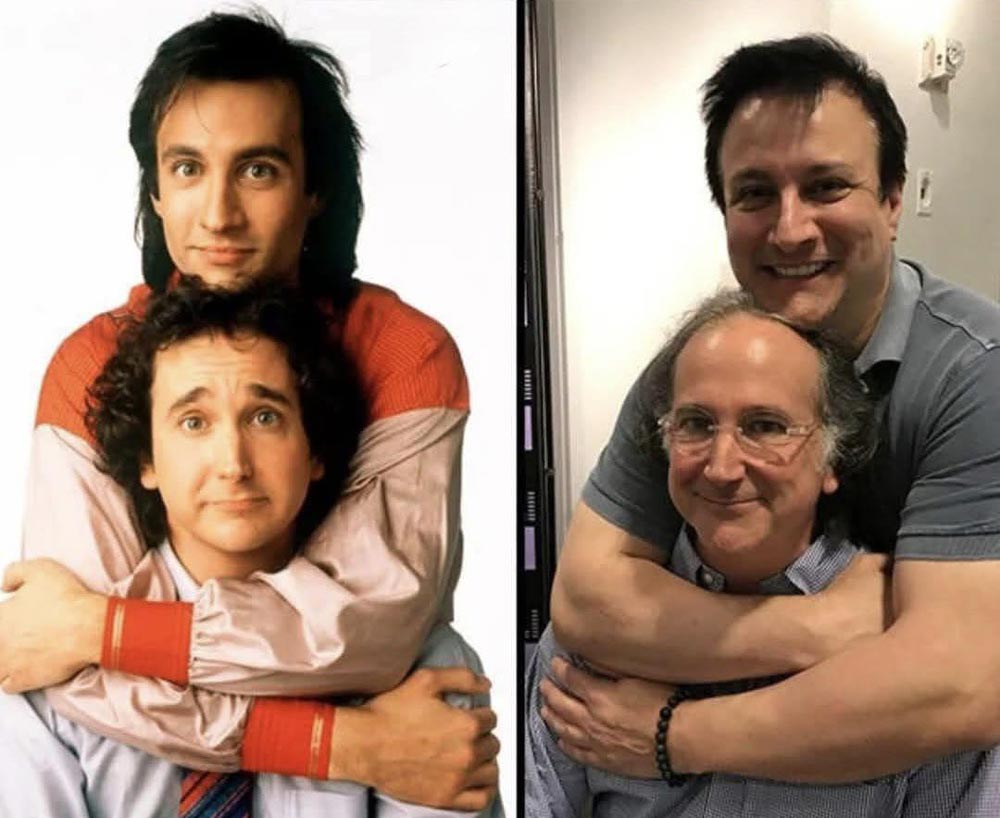 Two men pose together in both a vintage photo and a recent recreation. In both images, one man stands behind the other, hugging him from behind and smiling, highlighting their friendship over the years.