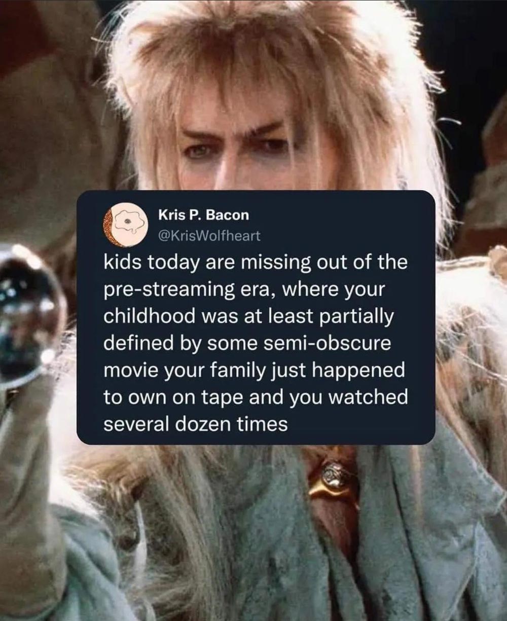 A tweet is overlaid on an image of David Bowie as Jareth from the movie Labyrinth. The tweet reminisces about watching semi-obscure movies on tape repeatedly before the streaming era.
